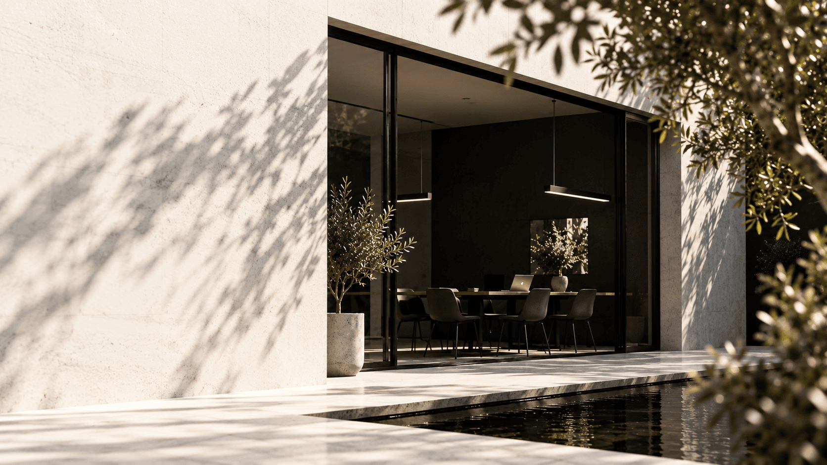 Modern black-framed architectural boardroom overlooking reflective pool and natural foliage